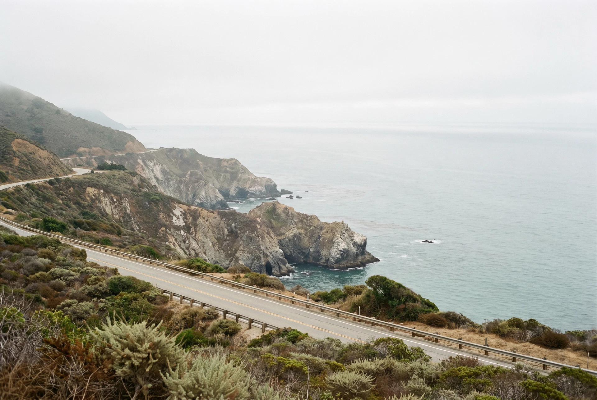 Muted Pacific coastline and coastal road along California's Big Sur region
